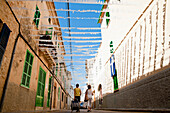 Women Going Shopping On A Decorated Street In Alcudia, Mallorca, Balearic Islands, Spain