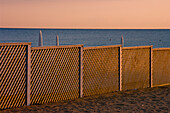 A fence on the beach at the water's edge; Paestum, Campania, Italy