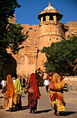 Frauen in traditionellen Röcken und Tüchern auf dem Weg zum Fort Tor in Jaisalmer, Rajasthan, Indien (c) Sue Carpenter/Axiom