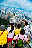 Tourists Enjoying The View From Victoria Peak Over The Skyline Of High Rise Buildings Of Victoria Harbour, Hong Kong Island And Kowloon; Victoria Peak, Hong Kong Island, China, Asia.