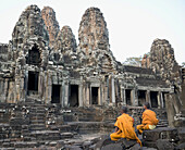 Buddhistische Mönche sitzen vor dem Bayon-Tempel, Angkor Wat