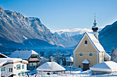 Schneebedeckte Alpenlandschaft mit Bergen, malerische Kirche, Ski- und Snowboardgebiet in Waidring, Österreichische Alpen, Österreich