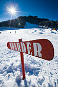 Skipiste mit Snowboard-Schild mit der Aufschrift 'boarder' im Ski- und Snowboard-Resort in Waidring, Österreichische Alpen, Österreich
