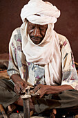 Niger, Sahara Desert, Agadez Region, Tuareg craftman making famous Cross of Agade; Agadez