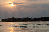 Italien, Marken, Sonnenaufgang über dem adriatischen Meer mit Felsen und Wolken; Porto San Giorgio