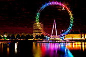 Riesenrad alias London Eye beleuchtet mit den Regenbogenfarben während der Pride Night, London, UK