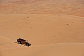 UAE, Abu Dhabi, Geländewagen fährt über Sanddünen; Liwa