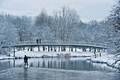 UK, East Sussex, Man paddle boarding down River Ouse in snowy conditions; Lewes