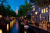 Blick entlang der kleinen Gracht mit der Spitze der Zuiderkerk Kirche am Ende in der Abenddämmerung; Amsterdam, Holland.