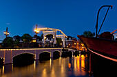 Magere Brug oder dünne Brücke in der Abenddämmerung, Amsterdam, Holland.