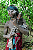 Young Mursi tribal man posing with an AK-47 Kalashnikov machine gun (a weapon & a new symbol of Mursi identity & social status) which found their way into the area during the Second Civil War in Sudan (1983 â€“ 2005). Makki / South Omo / Southern Nations, Nationalities & People's Region (Ethiopia).