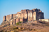 Die Festungsmauern des auf einem Hügel gelegenen Mehrangarh Fort über der Stadt Jodhpur; Jodhpur, Rajasthan, Indien