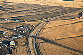 Roads and bridges traverse an arid landscape near urban developments.; Richland, Washington