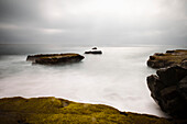 Eine lang belichtete Seelandschaft entlang eines felsigen Strandes in Santa Cruz; Santa Cruz, Kalifornien, Vereinigte Staaten von Amerika