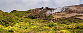 People hiking along the mountain trail near the top of the La Grande Soufriere  with it's crater emitting gases, Basse-Terre; Guadeloupe, French West Indies