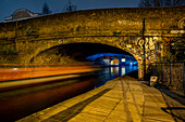 Bridge crossing Regent's Canal at Shoreditch with streaking lights at night; London, England