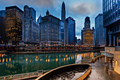 View of the Chicago River crossing and cityscape of iconic office towers, with 333 North Michigan, the London Guarantee Building, Mather Tower, 35 East Whacker Building and the Kemper Building in the City of Chicago on a rainy evening; Chicago, Cook County, Illinois, United States of  America