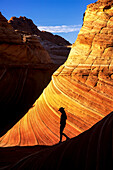 Silhouettierter Wanderer vor Navajo-Sandsteinformationen.