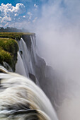 Powerful waterfalls of Iguazu Falls at Devil's Throat overlook.