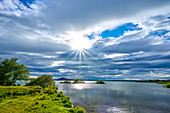 Die Sonne scheint über die ruhige Szene am Myvatn-See am nordöstlichen Ufer des Dorfes Reykjahlid in der Myvatn-Region im Sommer; Reykjahlid, Nordurland Vestra, Nordregion, Island