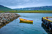 Colorful dory moored to a jetty in the harbor at Hauganes in the Northern Region of Iceland in summer; Hauganes, Nordurland Eystra, Iceland