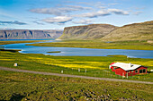 Ein einsames Haus in einer Fjordlandschaft im Nordwesten Islands; Hnotur, nahe Latrabjarg, Westfjorde, Island.