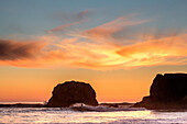 Silhouette eines Surfers auf einer Welle im kalten Wasser der Pazifikküste von Big Sur bei Sonnenuntergang; Big Sur, Kalifornien, Vereinigte Staaten von Amerika