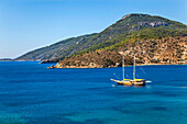 A gulet moored in a bay just west of Datca, Turkey.; The coast of the Datca peninsula, near Marmaris, western Anatolia, Turkey.