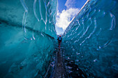 Eine Frau geht durch eine Gletscherspalte auf dem Vatnajokull-Gletscher.