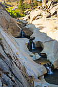 A hiker stands on the edge of one of the waterfalls at the Seven Teacups.