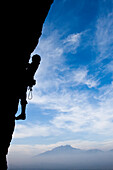 A climber ascends an overhang 500 feet off the ground.