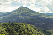 Überblick über den Mount Batur (Vulkan Kintamani) in South Batur mit bewölktem Himmel und üppiger Vegetation; Kintamani, Bangli Regency, Bali, Indonesien