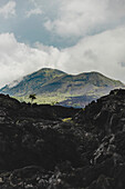Volcanic rock and view of Mount Batur (Kintamani Volcano) in South Batur with a cloudy sky; Kintamani, Bangli Regency, Bali, Indonesia