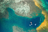 Blick von oben auf Boote, die in einer Lagune im Komodo Nationalpark vor Anker liegen, mit einer Sandbank und türkisfarbenem Küstenwasser; Ost Nusa Tenggara, Kleine Sunda Inseln, Indonesien