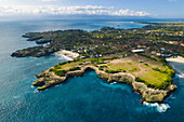 Aerial view of Devil's Tear and the rocky coastline of Nusa Lembongan with the turquoise waters of the Bali Sea crashing against the shore; Nusa Islands, Klungkung Regency, East Bali, Bali, Indonesia