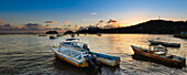 Boats moored in the harbor in Samana Bay along the shore of Samana at sunset; Samana Peninsula, Dominican Republic, Caribbean