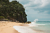 Wellen brechen gegen die Felsen und die Brandung rollt auf den Sand am Geger Beach in der Nusa Dua Resort Region; Geger Beach, Badung, Bali, Indonesien