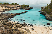 The rocky coast and beachfront of the resort town of Lembongan at the edge of the turquoise waters off the coast of Bali; Nusa Islands, Klungkung Regency, Indonesia