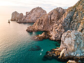 Luftaufnahme von Paddelboardfahrern entlang der felsigen Küste am Ostkap von Cabo bei Sonnenuntergang; Cabo San Lucas, Baja California Sur, Mexiko