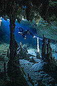 A cave diver explores a limestone passage; Tulum, Quintana Roo, Mexico