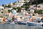 Kabinenkreuzer am Ufer des Hafens von Gialos, Insel Symi (Simi); Dodekanes-Inselgruppe, Griechenland