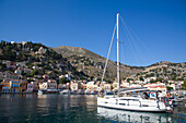 Segelboot und Kabinenkreuzer am Hafen von Gialos, Insel Symi (Simi); Dodekanes-Inselgruppe, Griechenland