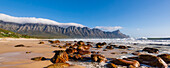 Rocky beach along the Atlantic Ocean at Kogel Bay with the Kogelberg Mountains in the background; Kogel Bay, Western Cape, South Africa