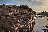 Rocks and a pool on the Atlantic coast, Devon, southwest England.; Damehole Point, Devon, Great Britain.