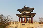 Ein traditioneller Glockenturm-Pavillon am Jiuhuashan-Tempel mit der modernen Stadt im Hintergrund, in der Nähe des Xuanwu-Sees, Nanjing, Provinz Jiangsu, China; Jiuhuashan-Tempel, Nanjing, Provinz Jiangsu, China.