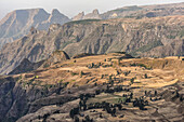 Scenic view of jagged mountain peaks with patchwork farmland on a plateau in the Simen Mountains in Northern Ethiopia; Simien Mountains National Park, Ethiopia