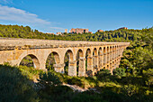 Altes, römisches Aquädukt, das Ferreres-Aquädukt (Aq?e de les Ferreres), auch bekannt als Pont del Diable (Teufelsbrücke), im Kontrast zu den modernen Gebäuden von Tarragona in der Ferne; Katalonien, Spanien