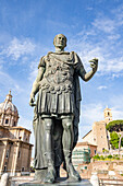 Nahaufnahme der Statua di Cesare (Statue von Julius Caesar) vor der Chiesa Santi Luca E Martina und den Ruinen des Foro Romano (Forum Romanum) im antiken Rom; Rom, Italien