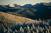 Snow covers trees and hills in the Adirondack Mountain region.; Adirondack Mountains, New York.
