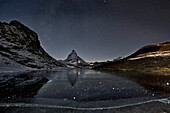 Das Matterhorn erhebt sich über einem zugefrorenen See; Gornergrat, Zermatt, Schweiz.